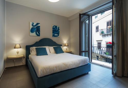 um quarto com uma cama e uma grande janela em Isula em Palermo