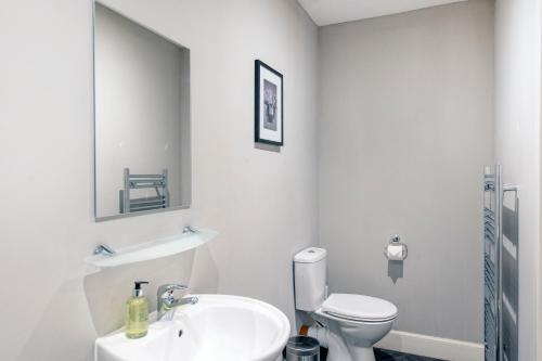 a white bathroom with a sink and a toilet at The Allan Park in Stirling