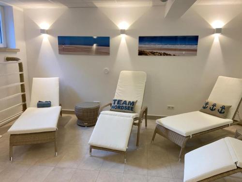a room with three chairs and a table and a picture at Inselresidenz Strandburg Apartment 209 in Juist