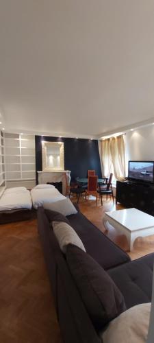 a living room with a couch and a television at Bridgestreet Champs-Elysées in Paris
