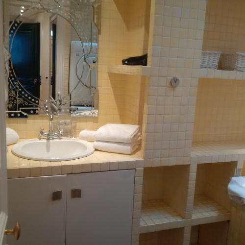 une salle de bain avec un lavabo et un miroir dans l'établissement Bridgestreet Champs-Elysées, à Paris