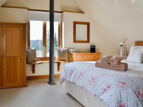 a bedroom with a bed with towels on it at Stratton Mill in Cirencester