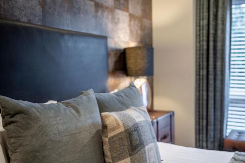 a bedroom with a bed with a pillow and a window at The Allan Park in Stirling
