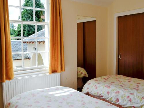1 dormitorio con 1 cama y una ventana con cortinas de color naranja en Strathisla, en Largs