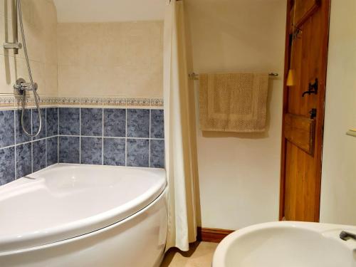 a bathroom with a tub and a toilet and a sink at Grange Farm Cottage in Barton in the Clay