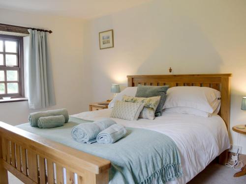 um quarto com uma cama grande e toalhas em The Oak em Newchurch