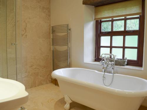 uma casa de banho com uma banheira, um WC e um lavatório. em The Oak em Newchurch