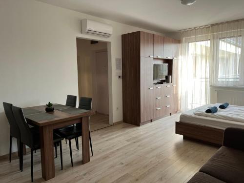 a living room with a dining room table and a bedroom at Hatvan Central Apartment in Debrecen