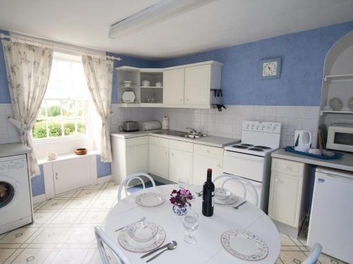 a kitchen with a table with a bottle of wine at Linden Cottage - E2549 in Matlock