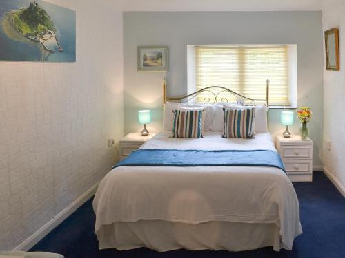 Saint CleerにあるRosecraddoc Manor - Natalie Janeのベッドルーム1室(大型ベッド1台、ランプ2つ付)