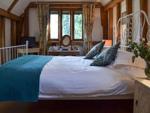 a bedroom with a large white bed with blue pillows at The Barn in Staple