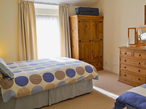 1 dormitorio con 1 cama, vestidor y ventana en Beech Cottage, en Windermere