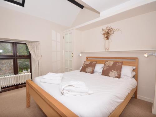 Schlafzimmer mit einem Bett mit weißer Bettwäsche und einem Fenster in der Unterkunft 8 Torwood Gables in Torquay