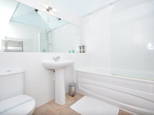 ein weißes Badezimmer mit einem Waschbecken, einer Badewanne und einem WC in der Unterkunft 8 Torwood Gables in Torquay
