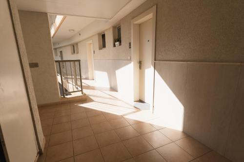 an empty hallway with a light shining through a door at neot golf kz place in Caesarea