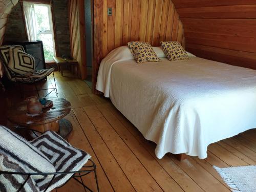 a bedroom with a bed and a wooden floor at Cabañas Nativo D'Ko in Carahuo