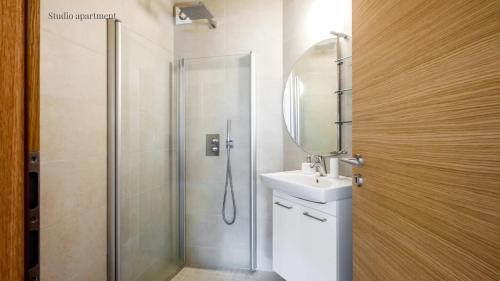 a bathroom with a shower and a sink and a mirror at Apartments Reykjavik in Reykjavík