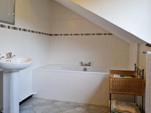 ein Badezimmer mit einem Waschbecken und einer Badewanne in der Unterkunft Oakleigh Cottage in Llangelynin