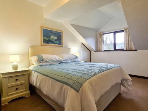 Schlafzimmer mit einem Bett und einem Fenster in der Unterkunft Oakleigh Cottage in Llangelynin