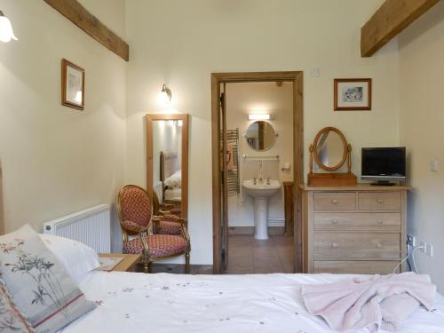 a bedroom with a bed and a sink and a mirror at Shepards Den in East Meon