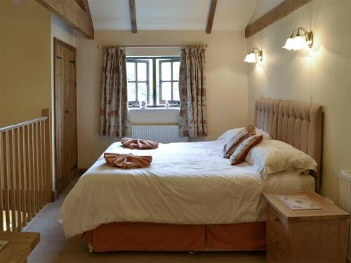 a bedroom with a large bed with a window at Shepards Den in East Meon
