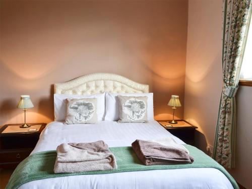 a bedroom with a bed with towels on it at Bluebells in Strathpeffer
