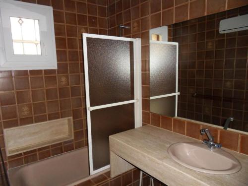 a bathroom with a sink and a tub and a mirror at La villa les oliviers in Vidauban