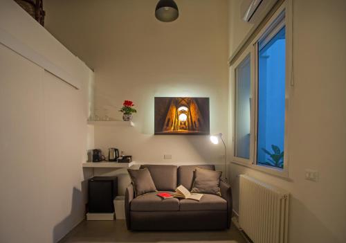 a living room with a couch with a book on it at Isula in Palermo