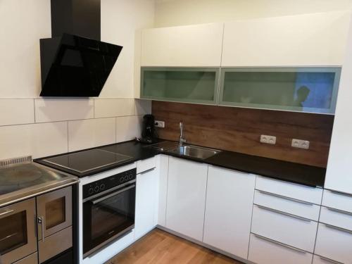 a kitchen with white cabinets and a sink at Ferienwohnung Eisenerz 80m² in Eisenerz