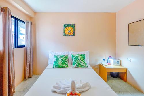 1 dormitorio con cama blanca y ventana en White Shamrock Beach Hotel, en Boracay