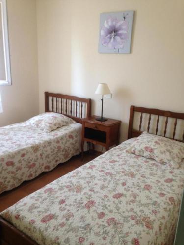 une chambre avec deux lits et une table avec une lampe dans l'établissement Les romarins, à Moissac-Bellevue