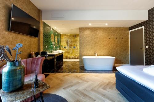 a bathroom with a tub and a bedroom with a bed at Hotel Karsten in Norg