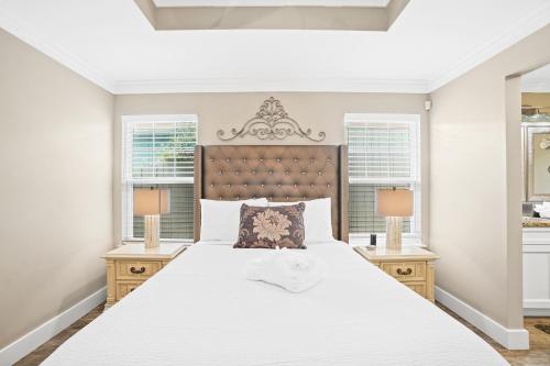1 dormitorio con 1 cama blanca grande y 2 lámparas en Pet Friendly Beach House - Paradise on Palm by Panhandle Getaways, en Panama City Beach