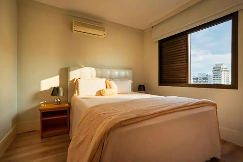 Un dormitorio con una cama grande y una ventana en Apto com WiFi piscina e proximo ao MASP Sao Paulo, en São Paulo