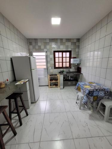 eine Küche mit einem Tisch und einem Kühlschrank in der Unterkunft Suítes Angra Sol e Mar in Angra dos Reis