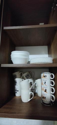 a shelf with cups and plates and other dishes at Villa Bayern in Bakuriani in Bakuriani
