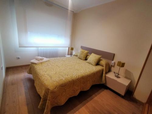 a bedroom with a bed with a yellow bedspread at Casa Abeleira in Arzúa