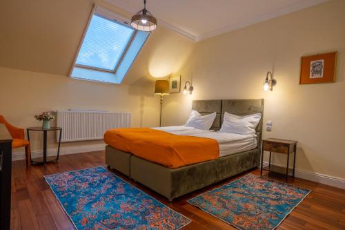 a bedroom with a bed with an orange blanket and a window at Vila Missy in Deva