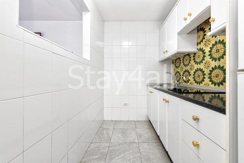 a white kitchen with white cabinets and a tile floor at Apartamento Los Molinos in Playa del Ingles