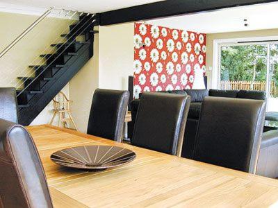a dining room with a wooden table and chairs at Still Waters in Wroxham