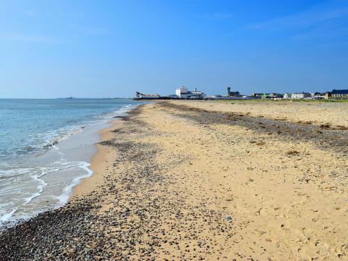 a beach with rocks and the ocean on a clear day at Still Waters in Wroxham