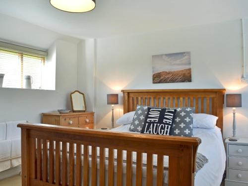 a bedroom with a bed with a wooden headboard at Pottery Cottage in Broadway