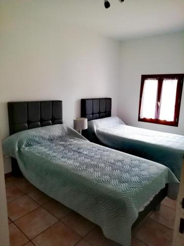 une chambre avec deux lits dans une pièce dans l'établissement L'audiberte, à Laouque