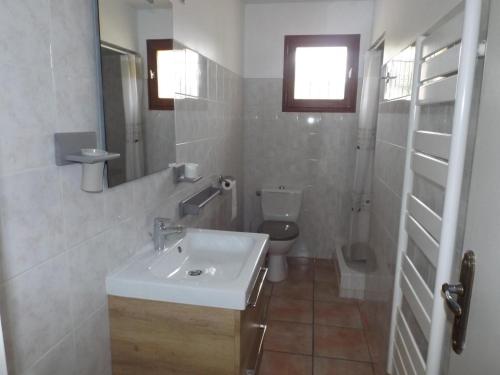 une salle de bain blanche avec un lavabo et des toilettes dans l'établissement L'audiberte, à Laouque