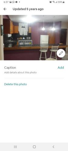 a screenshot of a kitchen with two chairs in a room at Seaview Hideaway in Port-of-Spain