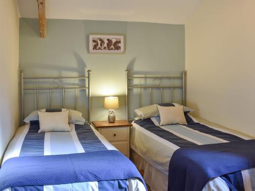 two beds in a room with blue and white at The Granary in Great Ormside
