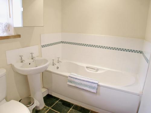 a bathroom with a sink and a tub and a toilet at The Granary in Great Ormside