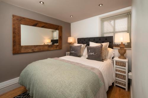 a bedroom with a large bed and a mirror at The Old Parlour at Cheshire Boutique Barns in Nantwich