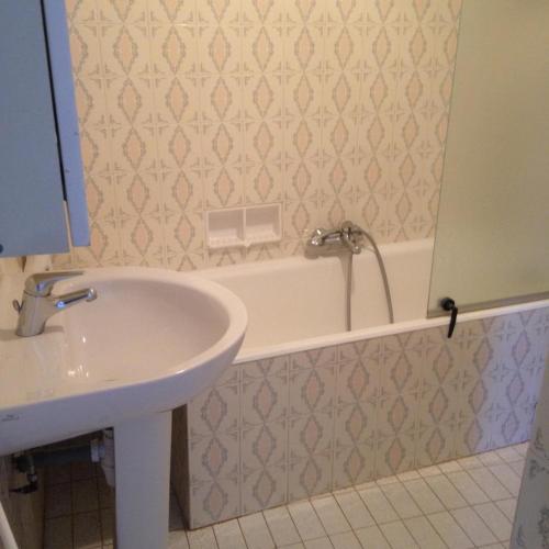 une salle de bain avec un lavabo et une baignoire dans l'établissement Les arcades, à Moissac-Bellevue