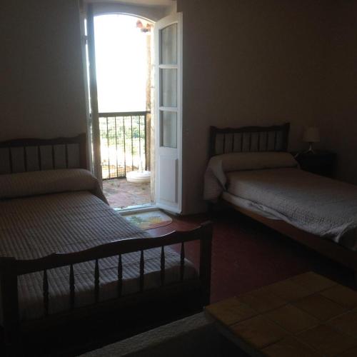 - une chambre avec 2 lits et une porte donnant sur un balcon dans l'établissement Les arcades, à Moissac-Bellevue